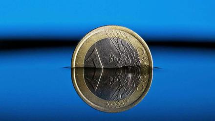 Eine Ein-Euro-Münze steht zur Hälfte im Wasser.