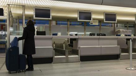 Schon beim Warnstreik verwaist: Eine Flugreisende steht in Berlin-Tegel an einem leeren Check-in-Schalter. 