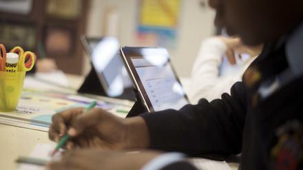 Schüler sitzen vor Tablet-Computern.