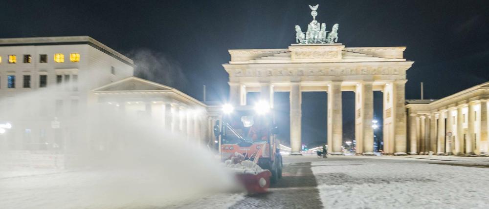 Ein Schneeräumfahrzeug vor dem Brandenburger Tor.
