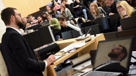 Ein Professor steht vor Studierenden im Hörsaal.