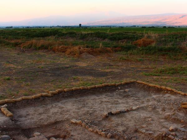 Ausgrabungsstätte in karger Landschaft im Norden Israels. Auf dem Boden ist altes Mauerwerk erkennbar.