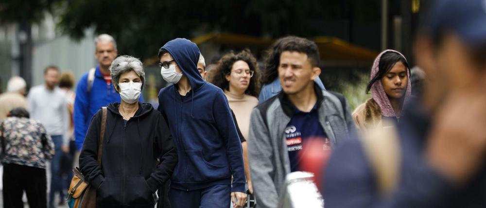 Brasilianer in Sao Paulo tragen Mundschutz, um sich vor dem Virus zu schützen.