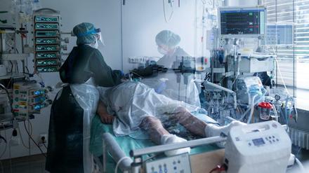 In einem Krankenhaus betreuten Mitarbeiterinnen der Pflege in Schutzausrüstung einen Corona-Patienten.