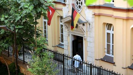Ein Mann betritt ein Gebäude, über dessen Portal eine türkische und eine deutsche Flagge zu sehen sind.