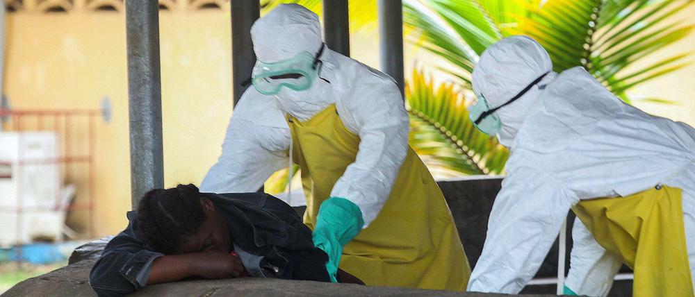Zu wenig, zu spät. Helfer holen eine Ebola-Tote aus dem Wartebereich eines Krankenhauses in Liberias Hauptstadt Monrovia ab. Sie ist eine von 1350 Menschen in Westafrika, die bisher an dem Virus starben.