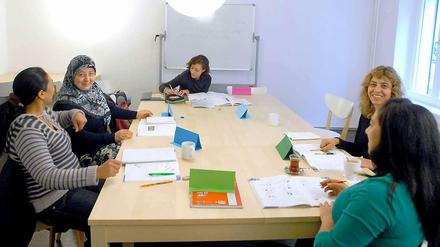 Frauen mit Migrationshintergrund sitzen in einem Deutschkurs im Elterncafé.