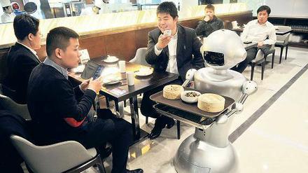 Die Zeiten ändern sich. Geschäftsleute im größten Roboter-Restaurant Chinas in Hefei, Provinz Anhui. 30 Roboter kochen, servieren und begrüßen die Gäste. 