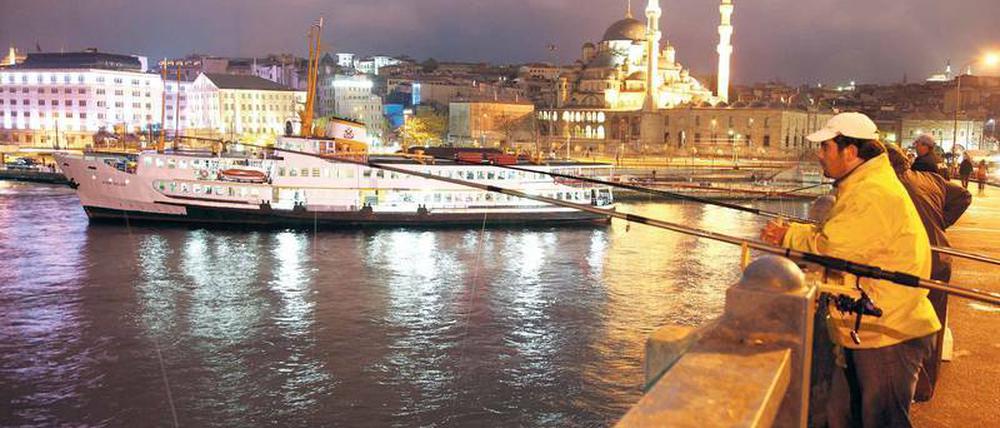 Volkssport in Istanbul. Angeln im Bosporus von der Galatabrücke aus, die das Goldene Horn überspannt. 