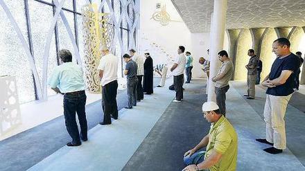 Muslimische Männer stehen in einer Moschee in Bayern.