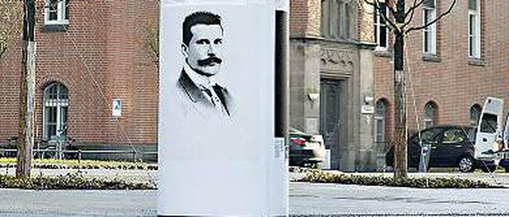 Vor einem Gebäude der Charité steht eine Gedenksäule mit Biografien von Mitarbeitern, die im Nationalsozialismus verfolgt wurden.