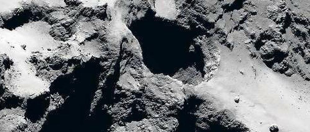 Bis zu 200 Meter tief reichen die schachtartigen Vertiefungen. An den Rändern ist der schichtweise Aufbau des Kometen zu erkennen. Die Aufnahme wurde im September 2014 aus 28 Kilometern Entfernung gemacht.