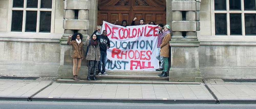 Denkmalsturz. „Dekolonialisiert die Bildung. Rhodes muss fallen“, fordern Studierende vor dem Oriel College in Oxford. Sie stören sich an der Statue des Südafrika-Kolonialisten Cecil Rhodes, die in der Nische unter dem Giebel steht. 