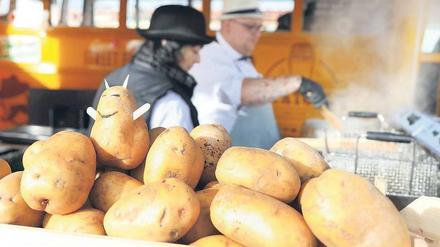 Kartoffeln und Pommes-Frites-Herstellung an einem Marktstand.