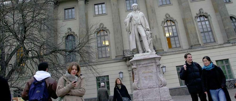 Studierende stehen vor dem Hauptgebäude der Humboldt-Universität zu Berlin.