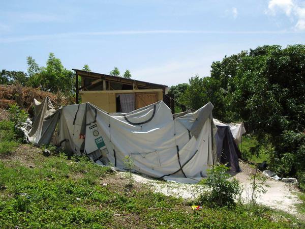 Oft nutzen die Menschen die Zelte, in denen sie gelebt haben, als Zaun und Sichtschutz für ihr neues Domizil - wie hier die Bewohner, die in dieses vom Arbeiter-Samariter-Bund gebaute Haus eingezogen sind.