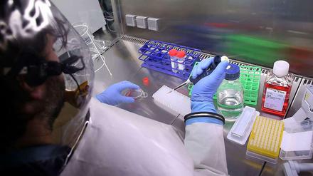 Eine Labormitarbeiterin hantiert mit Chemikalien.