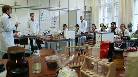Schüler unterrichten Schüler in einem Chemie-Labor.