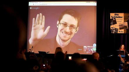 Edward Snowden ist auf einer Videoleinwand zu sehen, er wirkt dem Publikum im Saal zurück.