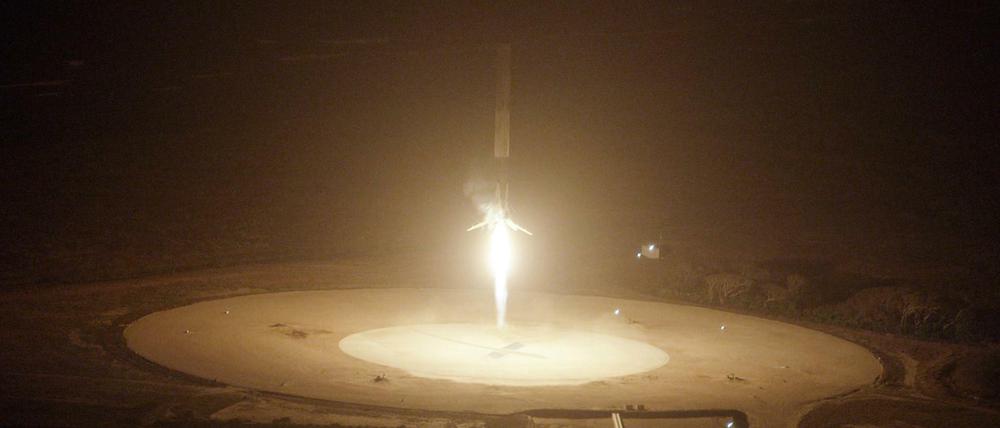 Landeanflug. Das Foto zeigt wie die "Falcon-9" aufrecht stehend zur Erde zurückkehrt und landet. 