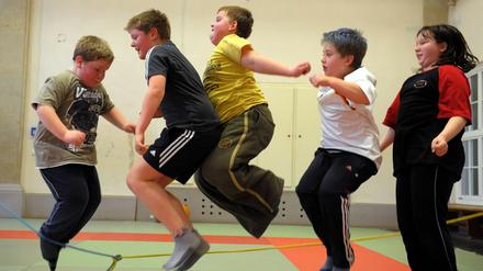 Übergewichtige Kinder nehmen in einer Sporthalle in Leipzig an einem Sportprogramm teil.