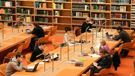 Forschende sitzen in der Staatsbibliothek vor ihren Laptops.