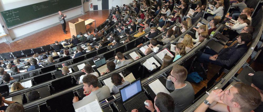 In einem großen Hörsaal der Universität Ulm nehmen Studierende an einer Vorlesung teil. 