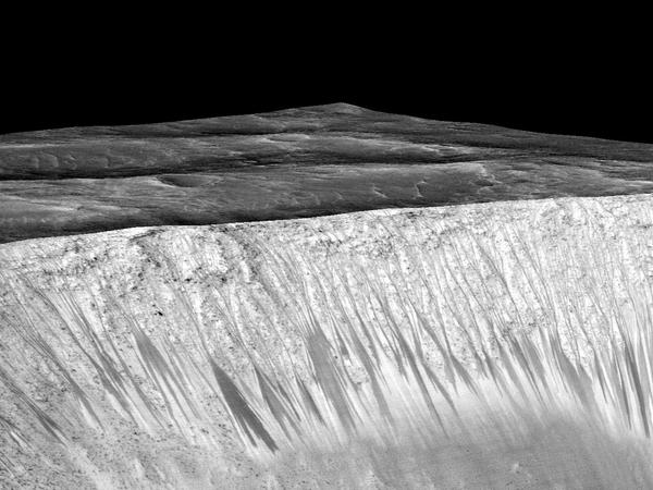 Fließend. Auch am Garni-Krater gibt es dunkle Linien, die auf Salzwasser hindeuten. Sie sind teilweise mehrere hundert Meter lang.