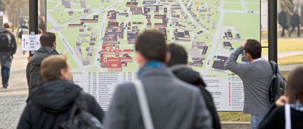 Studierende stehen vor einem Lageplan der TU Dresden.