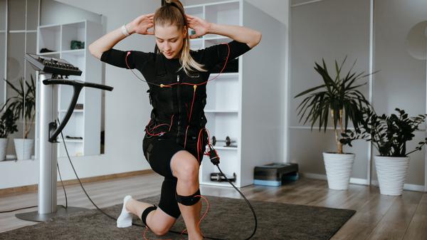 Eine Frau macht EMS-Training zu Hause. Mit Übungen kombiniert, ist es noch effektiver.