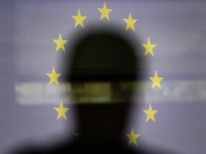 Eine Silhouette ist vor einer Projektion der EU-Flagge zu sehen (Symbolbild).