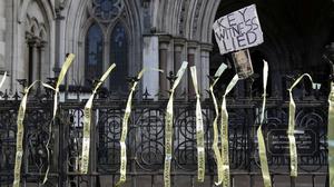 Am Tag der Auslieferungsanhörung des WikiLeaks-Gründers Julian Assange in London wird ein Transparent an einem Zaun vor dem High Court angebracht.