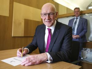 Der neue Vorsitzende der Scottish National Party (SNP), John Swinney, unterzeichnet im schottischen Parlament in Edinburgh sein Nominierungsschreiben für das Amt des Ersten Ministers. 