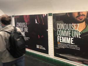 Ein Mann läuft an einer Plakatwand in einer Metro-Unterführung vorbei. „Fahre Auto wie eine Frau“ (Conduisez comme une femme) steht in großen Buchstaben auf den Plakaten, die seit Kurzem unter anderem in der Pariser Metro hängen.