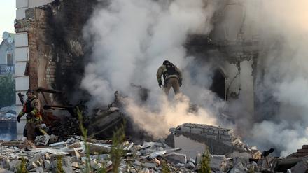 Ein Feuerwehrmann geht in Charkiw durch den Qualm eines Hauses, das nach russischem Beschuss in Flammen steht.  