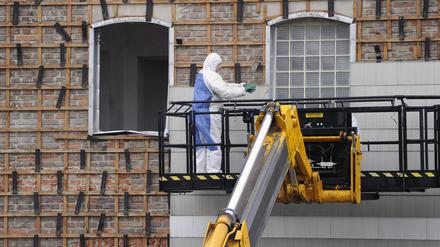 Alte Asbestplatten an einer Hausfassade werden entfernt.