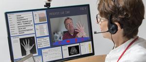 Eine Ärztin kommuniziert mit dem Patienten über eine Webcam.