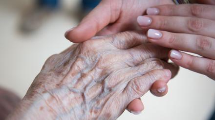Eine Pflegerin hält die Hand einer Bewohnerin in einem Seniorenzentrum.  (Symbol)