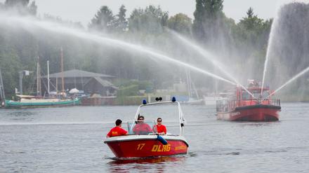 Wie praktisch, wenn die Feuerwehr für ein bisschen Erfrischung sorgt, oder? Hinten: Berlins Feuerwehrboot aus Spandau.
