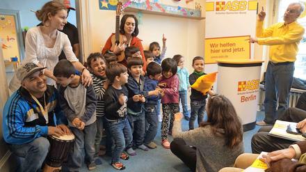 Sprachlehrer Christian Liebisch (r.) gibt den Ton an: Eine Gesangsprobe mit Flüchtlingskindern im früheren Rathaus Wilmersdorf.