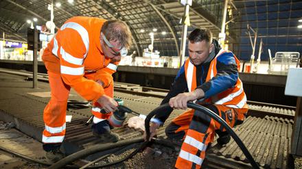 Arbeiter durchtrennen ein Kabel im Hauptbahnhof, um das neue Zugsicherungssystem einzubauen.