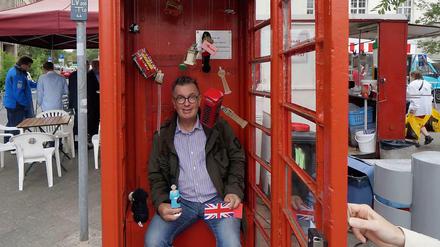 Ein Englishman in Berlin: Michael Hughes hat die rote Telefonzelle am Fehrbelliner Platz mit Souvenirs bestückt, die er für seine Fotos nutzt.