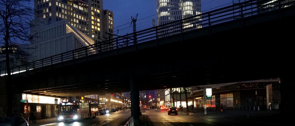 Wegen defekten Lichts finstere Bahnbrücke über der Kantstraße vor den erleuchteten Zoofenster-Hotels.
