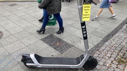 Rücksichtslos auf dem Gehweg abgestellter E-Roller mit "Gelber Karte" des Allgemeinen Blinden- und Sehbehindertenvereins Berlin (ABSV).