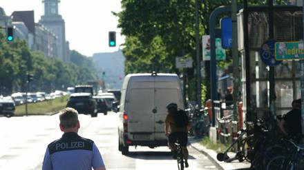 Transporter parkt auf Radweg, Radfahrer muss ausweichen, Polizist beobachtet.