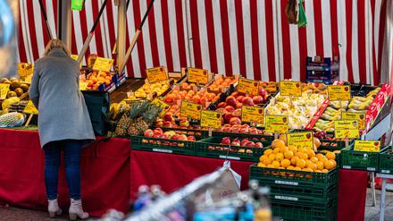 Berliner Wochenmarkthändlerin sortiert ihre Lebensmittel-Ware.