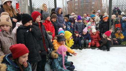 Kinder im Schnee bei einer Evakuierungsübung einer Schule in Charkiw in der Ukraine.