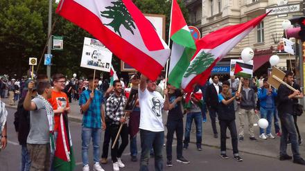 Libanesische und palästinensische Flaggen sowie das Konterfei des iranischen Revolutionsführers: Israelfeinde am Adenauerplatz zu Beginn der Demonstration.