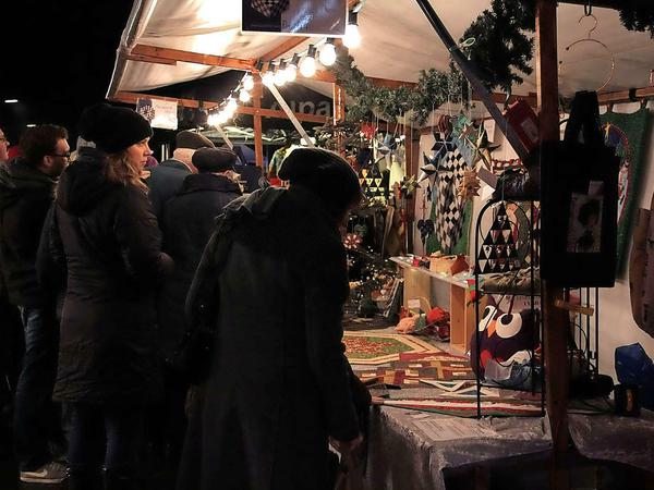 An Kunsthandwerkerständen stöbern: Eine Szene des Weihnachtsmarkts 2014 in der Preußenallee.