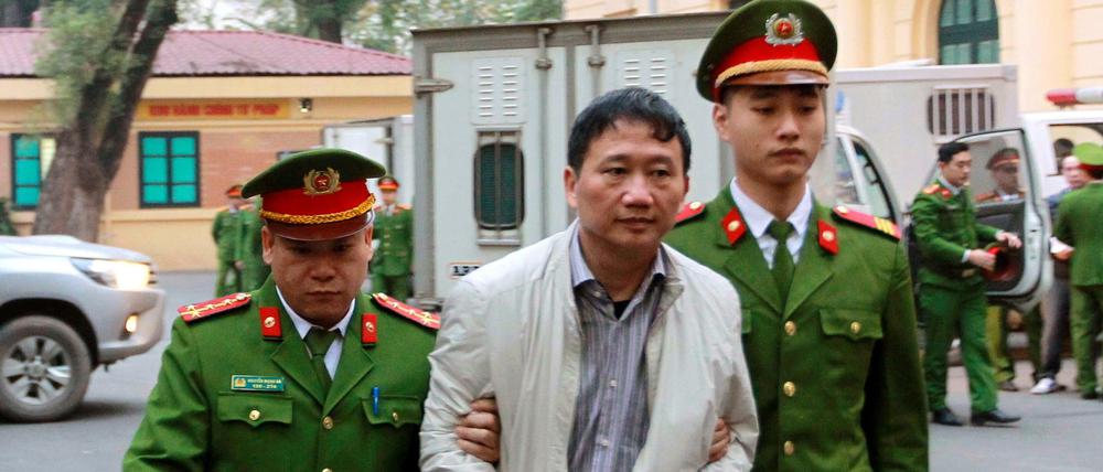 Der viatnemsische Geschäftsmann Trinh Xuan Thanh (Mitte) auf dem Weg zu seinem Prozess in Hanoi.